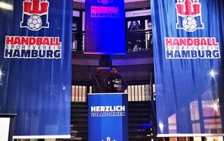 Bühne mit großen Handball Sportverein Hamburg Bannern und Rednerpult im Veranstaltungsbereich