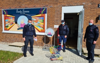 Drei Beamte in Uniform und Maske vor Laden „Tante Emma“ mit Einkaufswagen