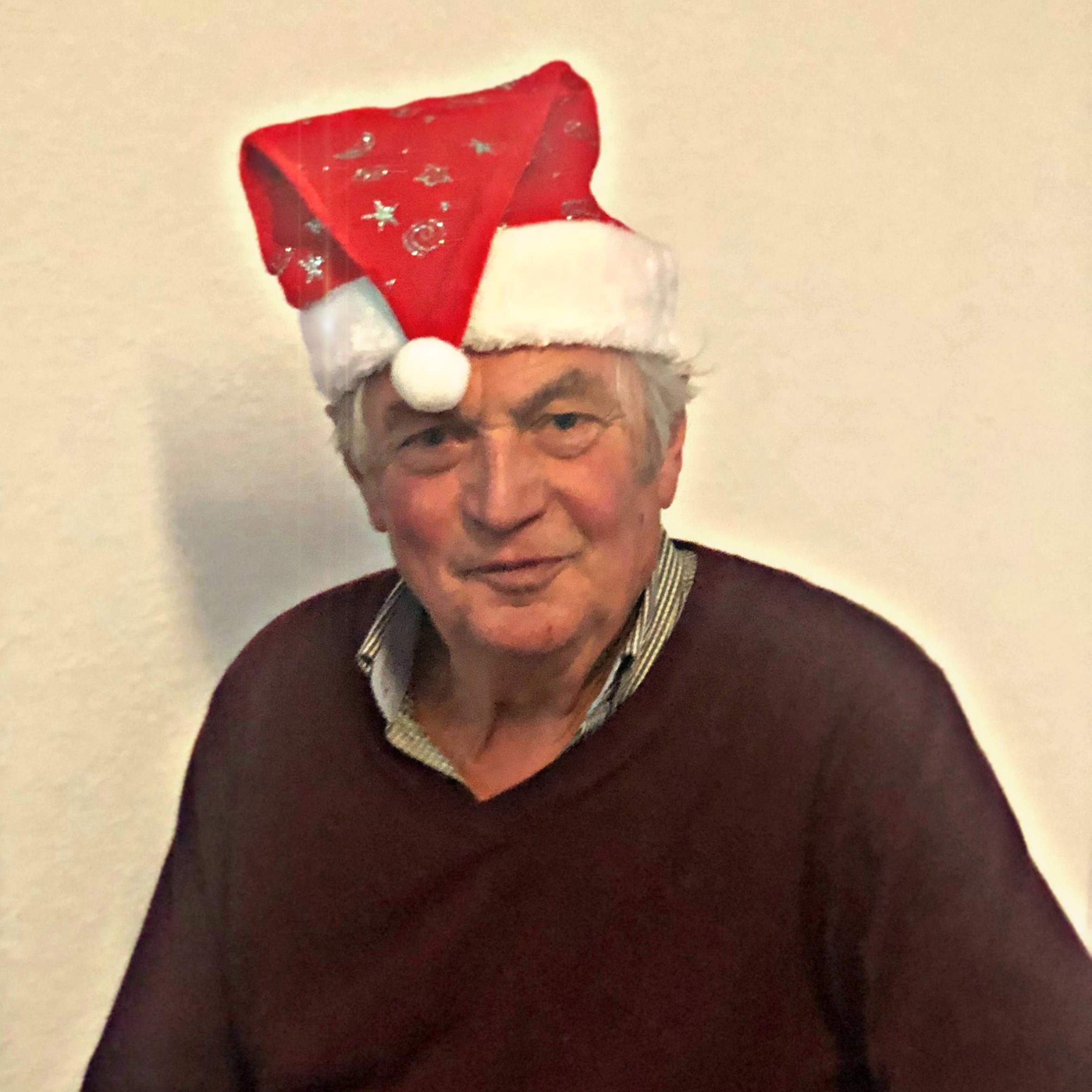 Nahaufnahme eines lächelnden Seniors mit Weihnachtsmütze
