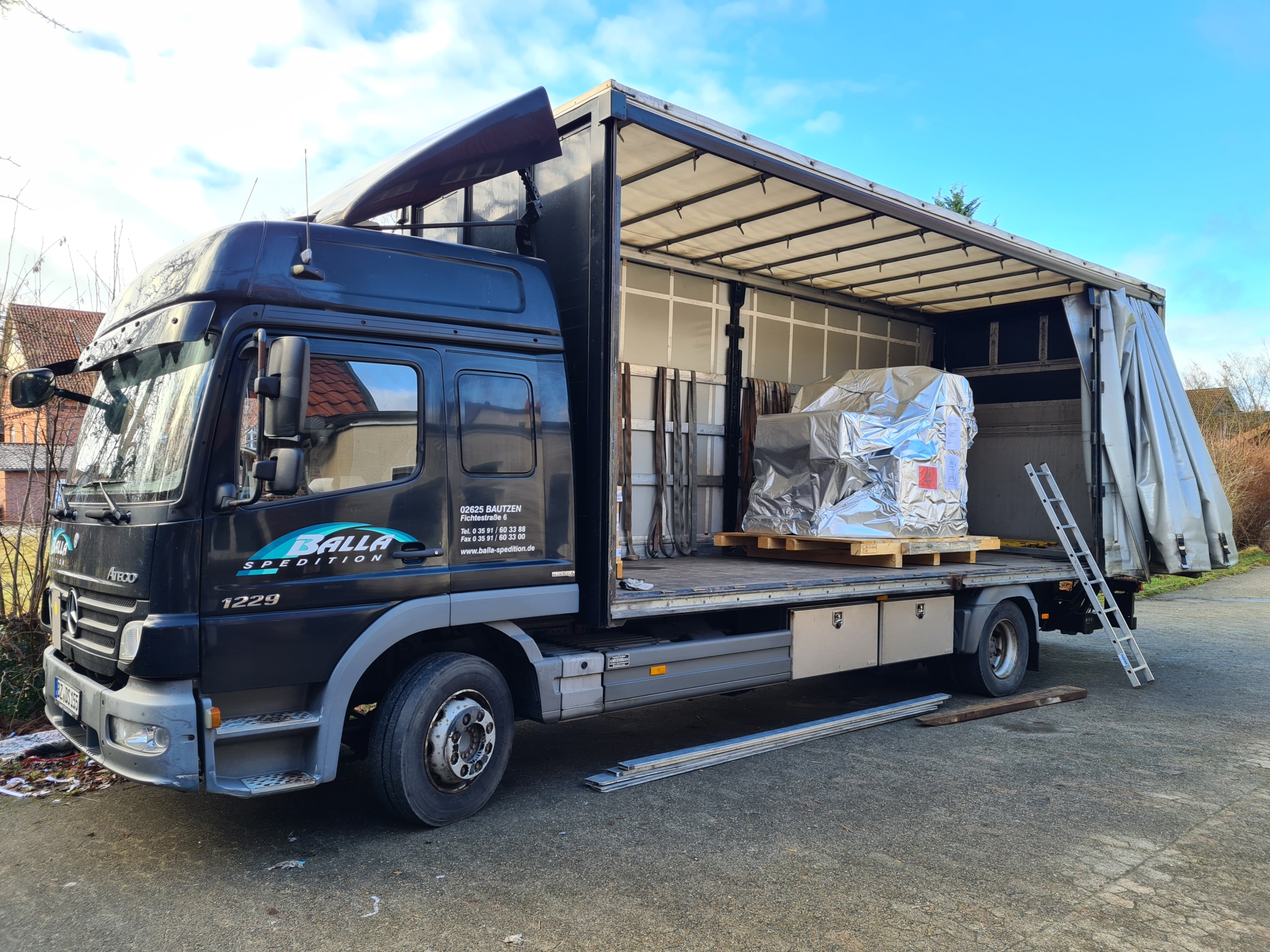 Speditions-LKW mit offener Ladefläche, Schneidemaschine in Folie auf Palette