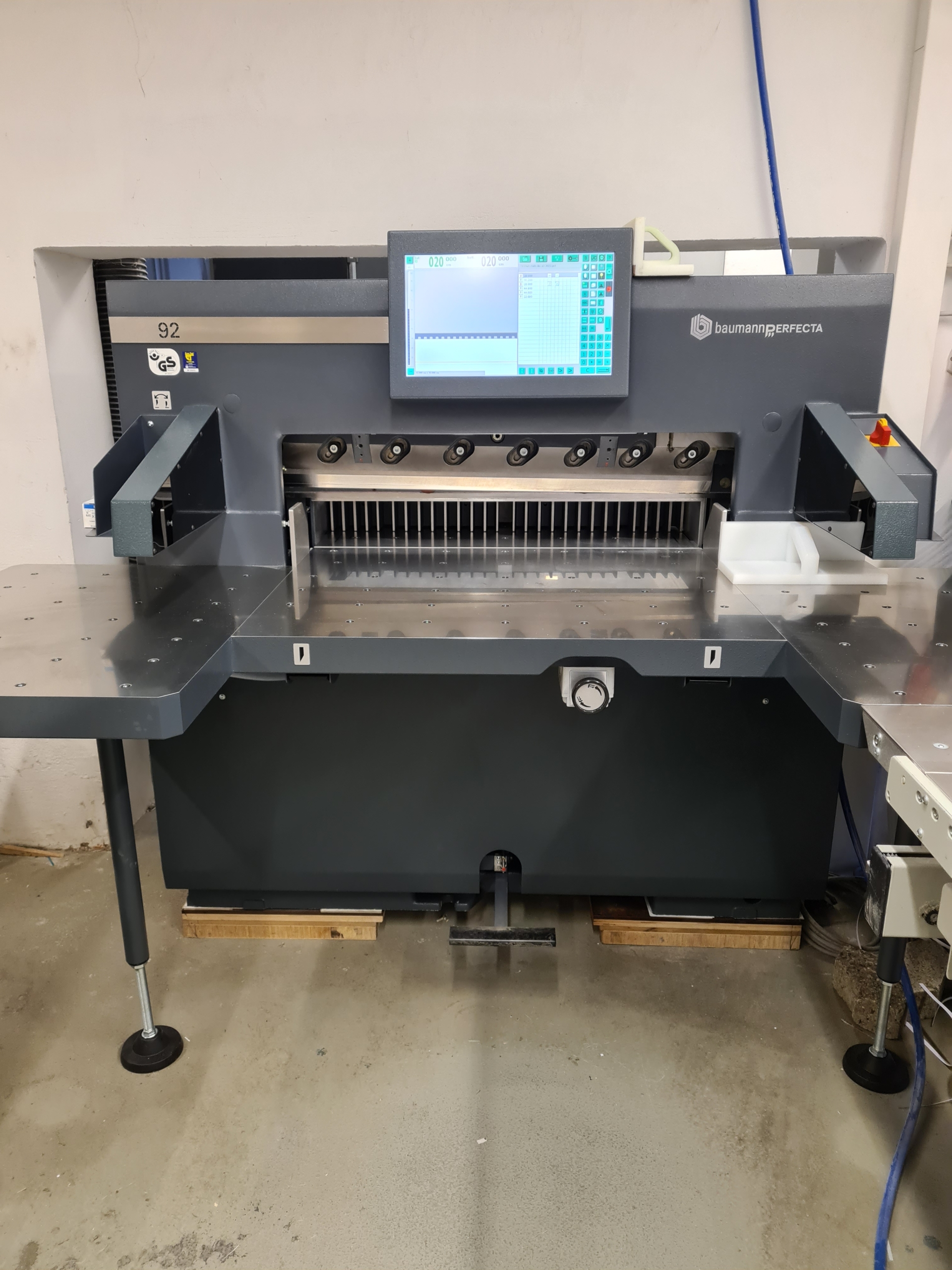 Aufgestellte Baumann Perfecta 92 Schneidemaschine mit Display im Betriebsraum
