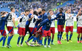 HSV-Spieler jubeln gemeinsam auf dem Spielfeld vor begeistertem Publikum im Stadion