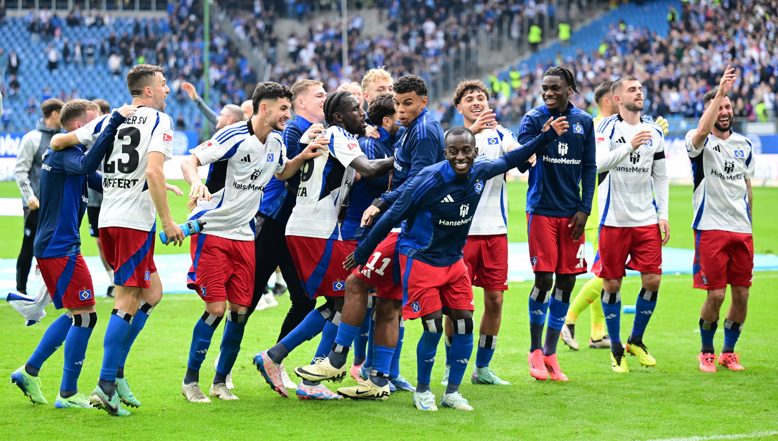 HSV-Spieler jubeln gemeinsam auf dem Spielfeld vor begeistertem Publikum im Stadion